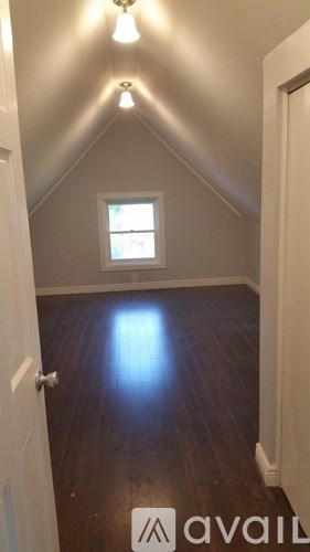 A room with a window and a wooden floor.