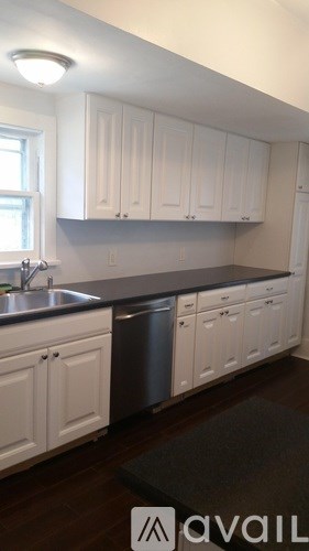 A kitchen with white cabinets and a black countertop.