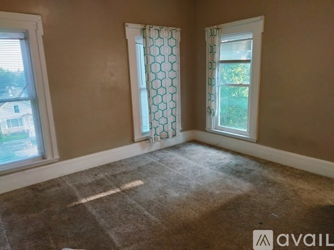 A room with two windows and a carpeted floor.