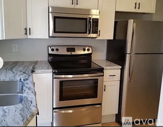 A kitchen with a stove, oven, microwave, and refrigerator.