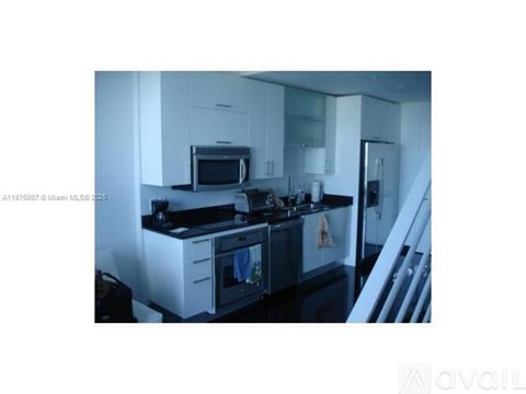 A kitchen with white cabinets and black appliances.
