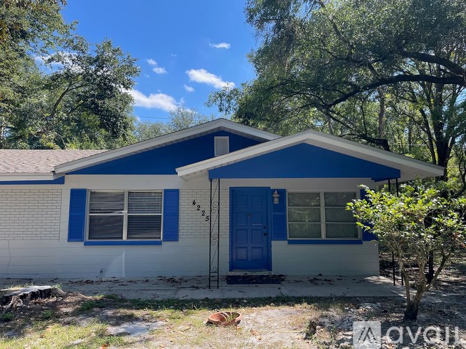 A blue and white house with a brown door and windows.