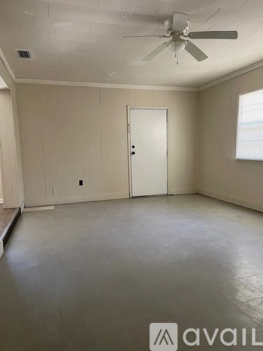 A room with a ceiling fan and a door.