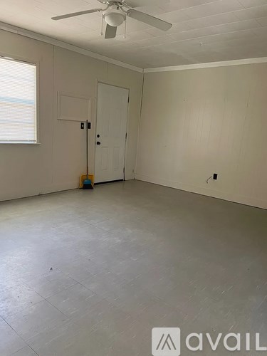 A room with a ceiling fan and a door.