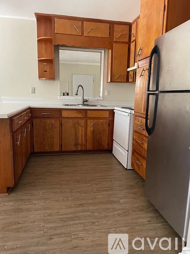 A kitchen with wooden cabinets and a white fridge.