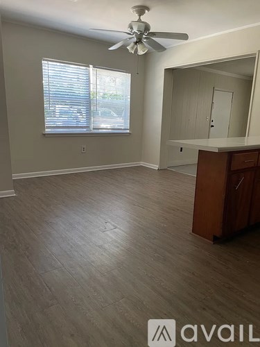 A room with a ceiling fan and wooden flooring.