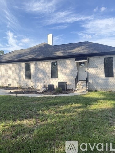 A house with a black roof and a white wall with a window and a door.
