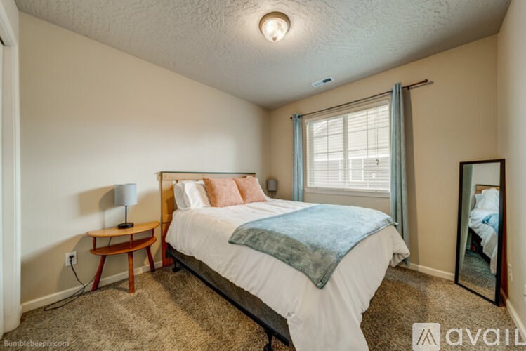 A bedroom with a bed, nightstand, and window.