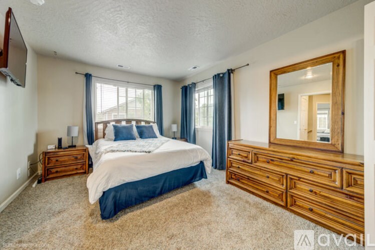 A bedroom with a bed, dresser, and mirror.