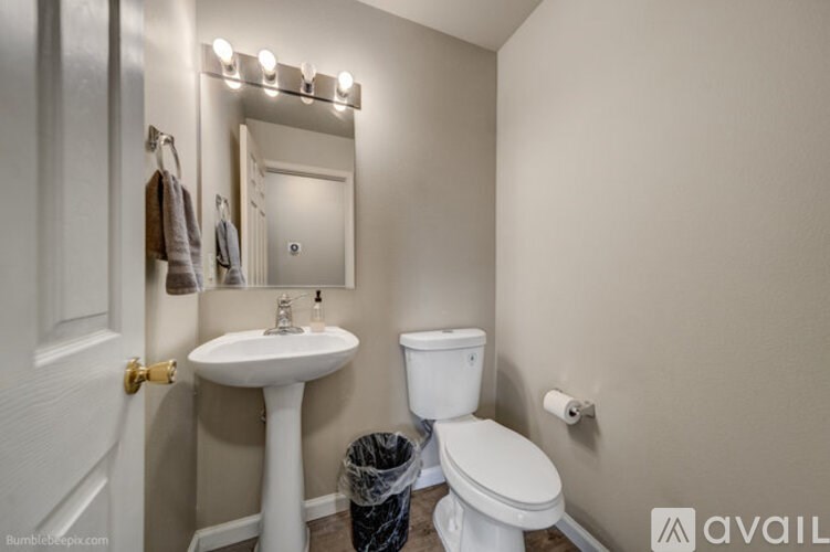 A bathroom with a white toilet, sink, and mirror.