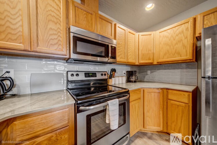 A kitchen with wooden cabinets and a stove top oven.