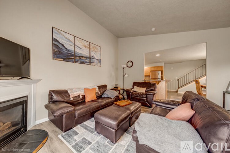 A living room with a fireplace and brown leather furniture.