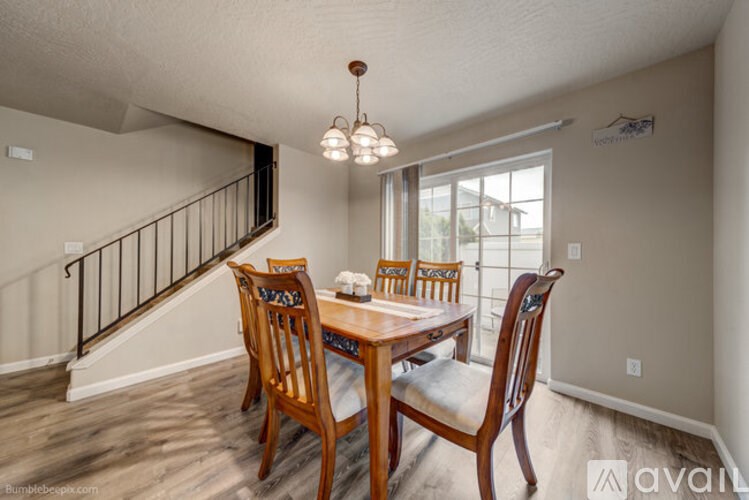 A dining room with a wooden table and chairs.