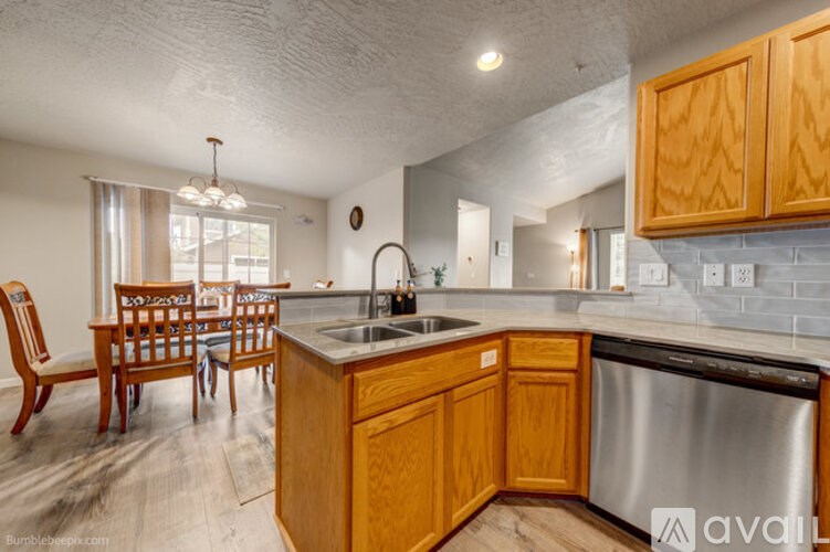A kitchen with wooden cabinets and a stainless steel dishwasher.