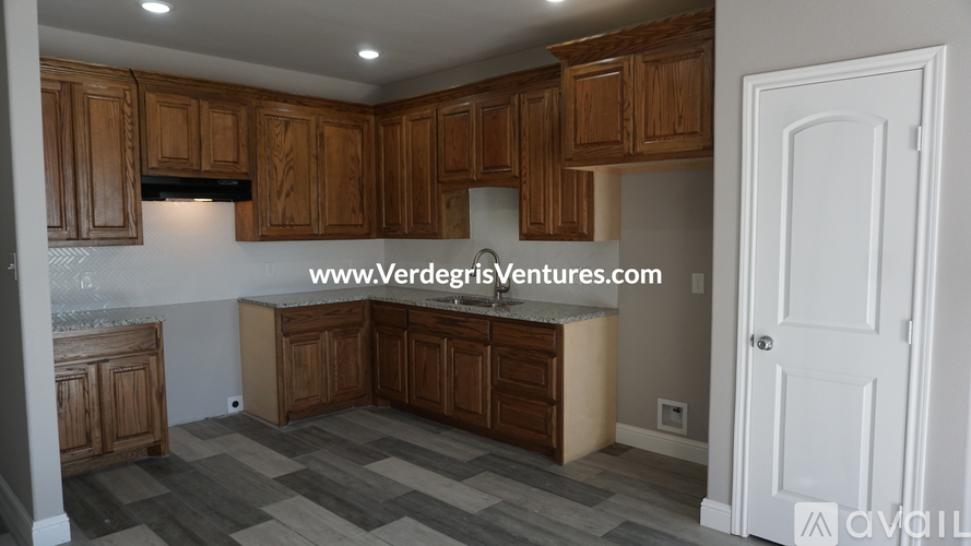 A kitchen with wooden cabinets and a white door.