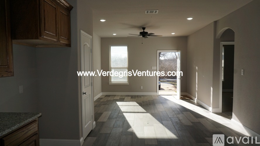 A room with a fan and a window that is for sale.