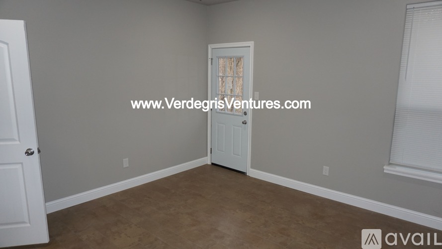 A room with a door and a window with blinds.