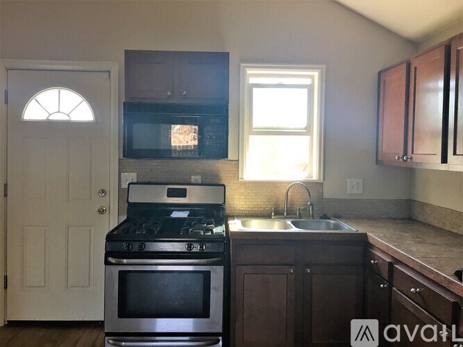 A kitchen with a stove, microwave, and cabinets.