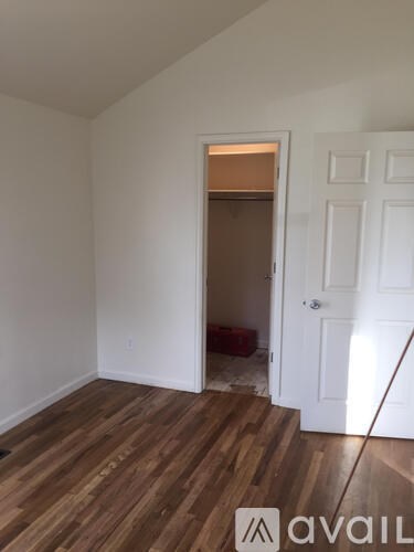 A room with wooden floors and a white door.