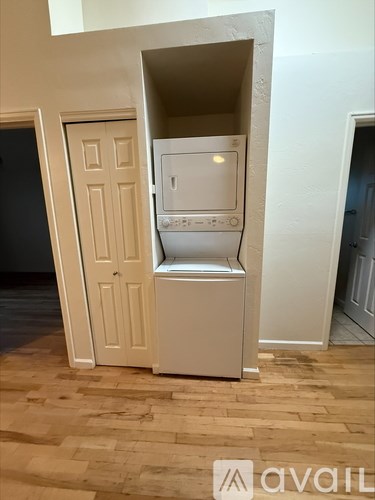 A white fridge freezer is in a corner of a room.