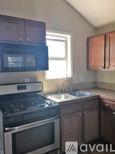 A kitchen with a stove, microwave, and cabinets.