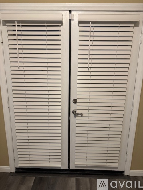 A white double door with blinds on it.