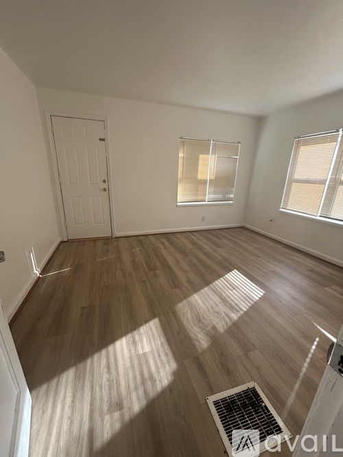 A room with wooden flooring and a white door.