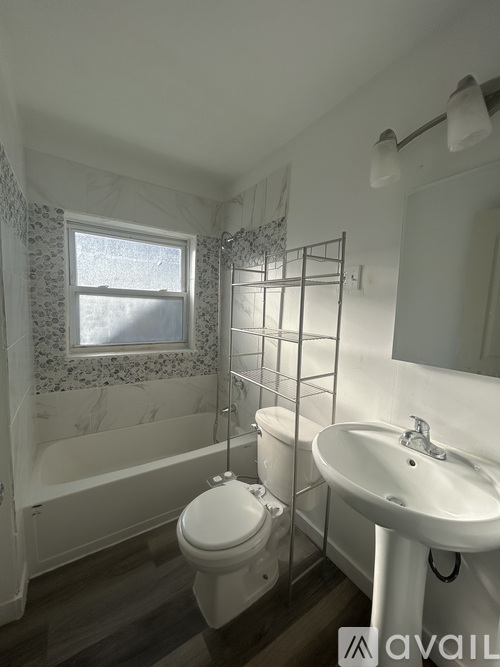 A bathroom with a toilet, sink, and bathtub.