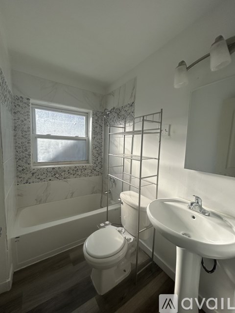 A bathroom with a toilet, sink, and bathtub.