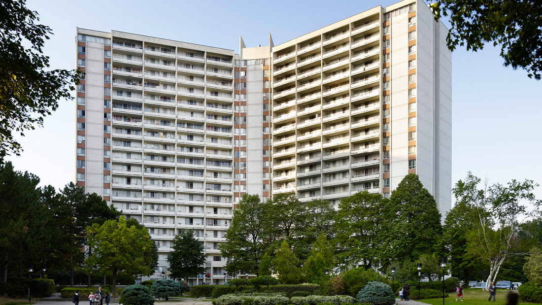 A large building with a lot of windows is surrounded by trees.