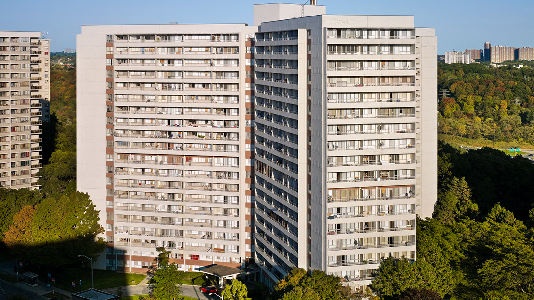 A large, grey apartment building with a lot of windows and balconies.