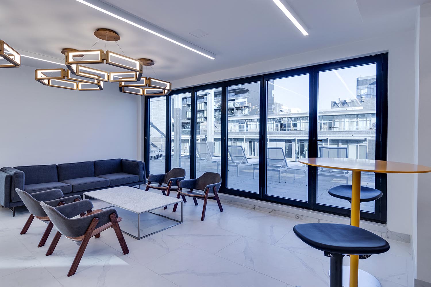 a living room with large windows and a table with chairs