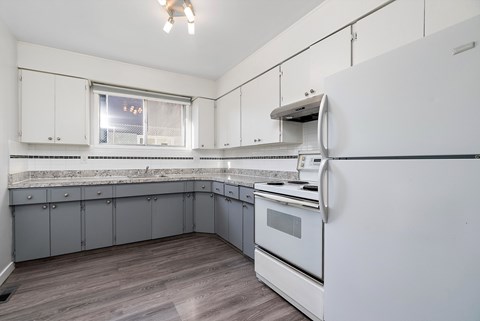 A kitchen with a white oven and grey cabinets.