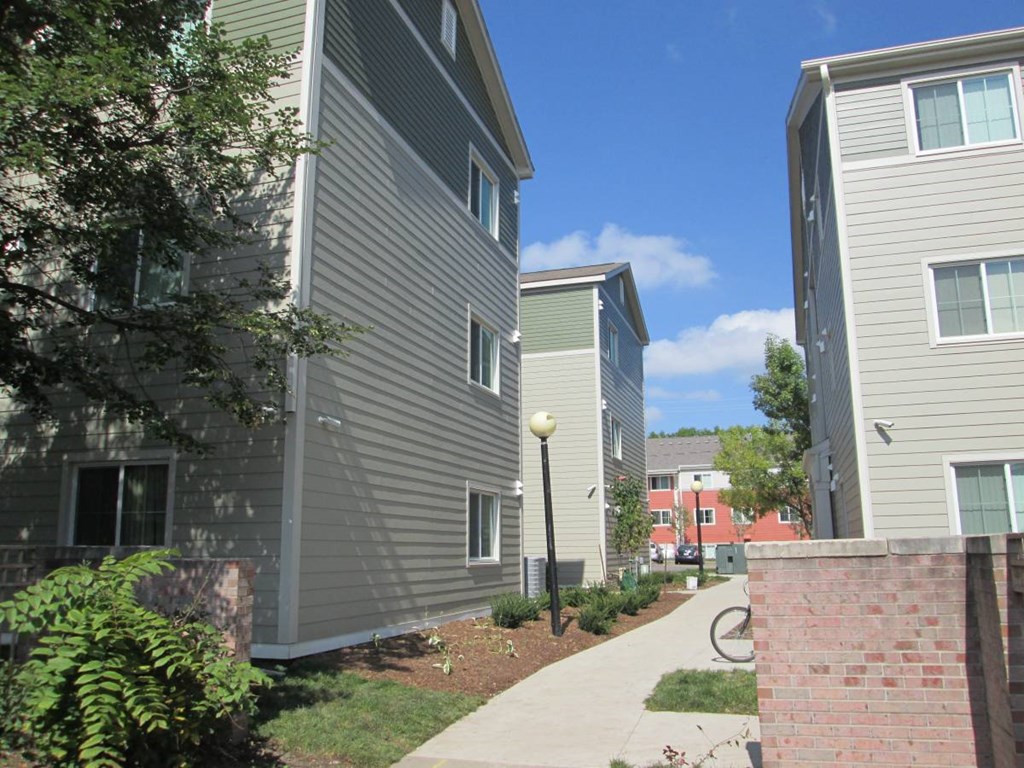 A residential area with apartment buildings and a sidewalk.