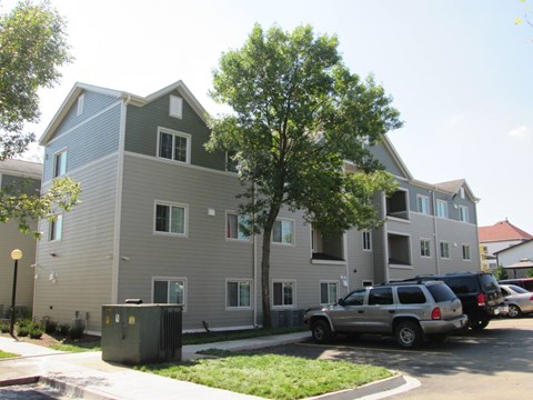 Apartment building with a tree in front of it.
