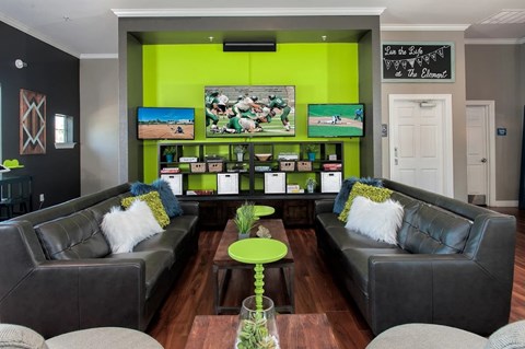 A living room with two grey couches and a green coffee table.