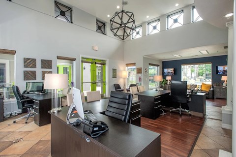A modern office space with desks, computers, and chairs.