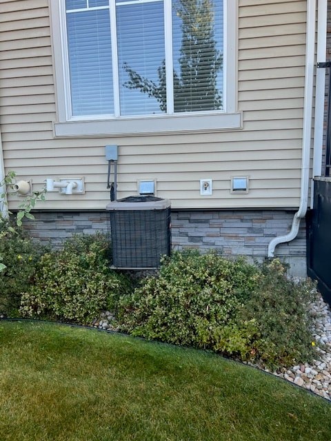 A house with a window and a wall with pipes and boxes on it.