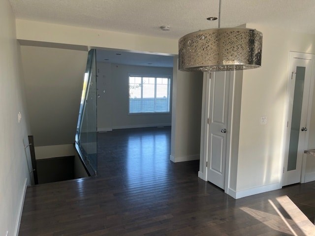 A room with a wooden floor and a glass door leading to a balcony.