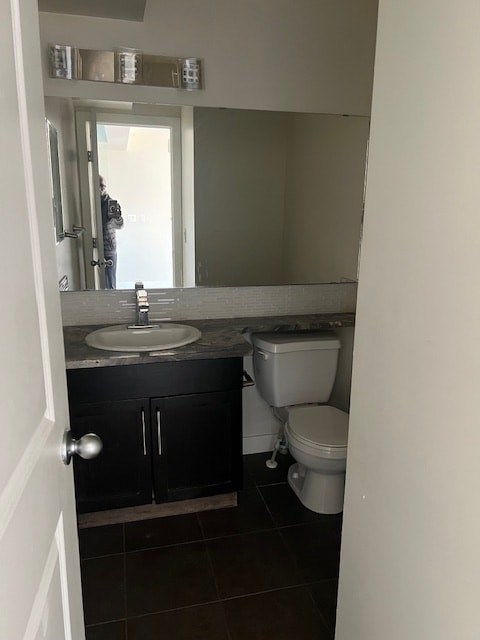 A bathroom with a toilet, sink and mirror.