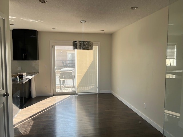 A room with a wooden floor and a glass door leading to a balcony.