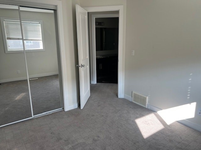 A room with a carpeted floor, a sliding glass door, and a white door.