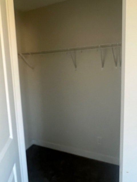 A white closet with a black carpet.