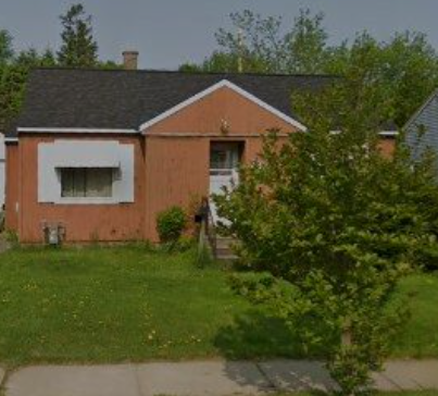 A small house with a white window and a brown roof.