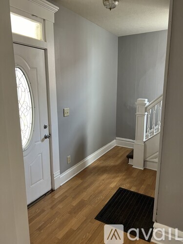 A hallway with a white door and a staircase.