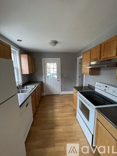 A kitchen with wooden cabinets and white appliances.