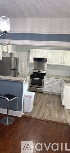 A kitchen with white cabinets and a blue wall.