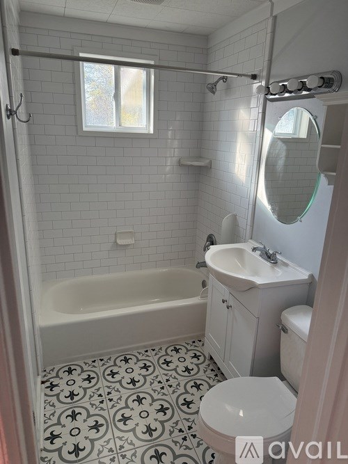 A bathroom with a white tub, sink, and toilet.