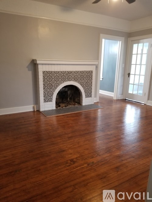 A room with a fireplace and wooden floors.