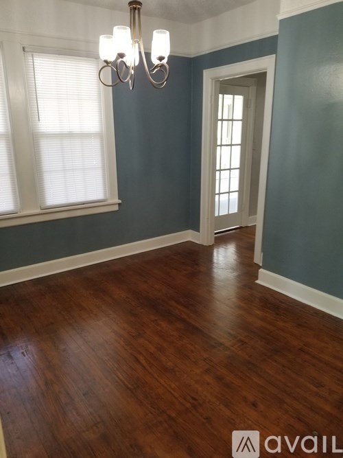 A room with wooden floors and a chandelier.